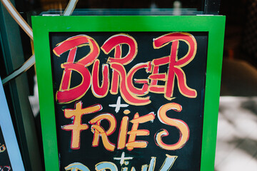 The words burger and fries drawn on a chalk board.