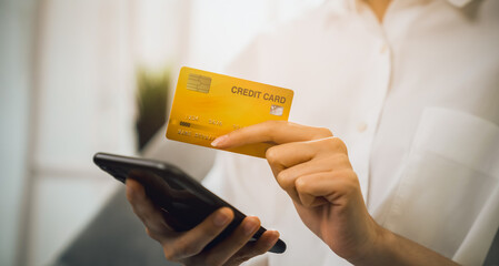 Hand holding smartphone and using application shopping online with payment by credit card online.