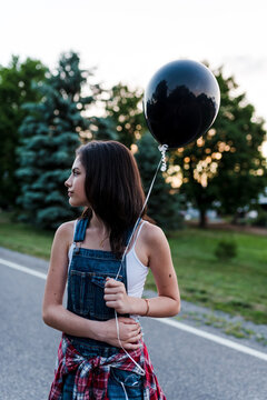 A teenage girl holding a balloon