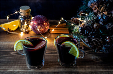 Christmas mulled wine with oranges and spices on wooden background.