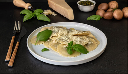 Cooked ravioli or tortelli with cheese, basil, and mushrooms.