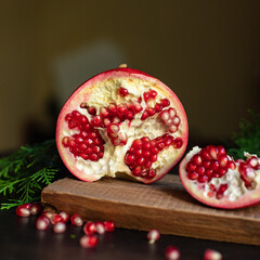 pomegranate red fruit sweet on the table and a twig of green christmas tree new year tasty treat serving size top view copy space for text food background rustic food background rustic