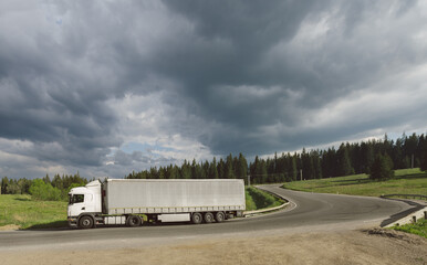 Cargo truck driving on a road though the countryside