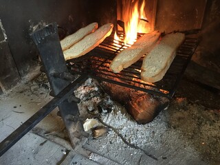 Toasting bread in the fireplace of a traditional house