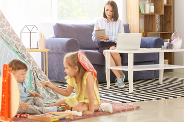 Working mother with little children at home