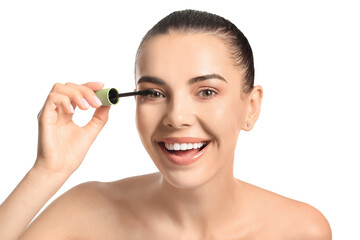 Fototapeta premium Beautiful young woman applying mascara against white background