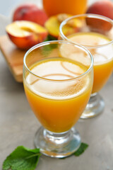 Glasses of fresh peach juice on table