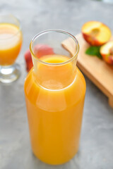 Bottle of fresh peach juice on table