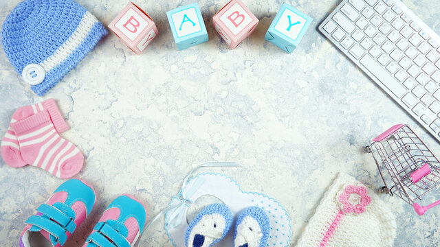 Baby nursery clothing mom bloggers desktop workspace with accessories and shopping cart on white textured background. Top view blog hero header creative composition flat lay. Negative copy space.