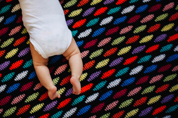 3 month old baby lying on a colorful homemade afghan blanket.