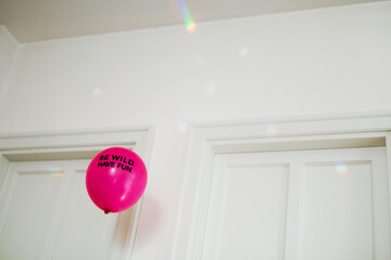 Fluo magenta balloon spelling Be wild. Have fun.