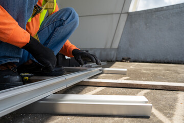worker wear all safety suit with blue jeans plant installing metal frame sheet on rooftop stock photo