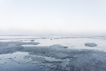 the water freezes and covers the sand with ice and snow on the seashore during the winter frost