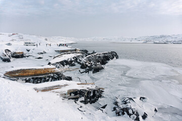 sunken old ships near the shore in the cemetery under the snow in winter