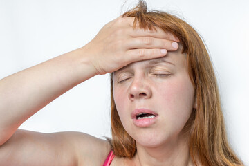 Woman with headache or migraine is holding her aching forehead