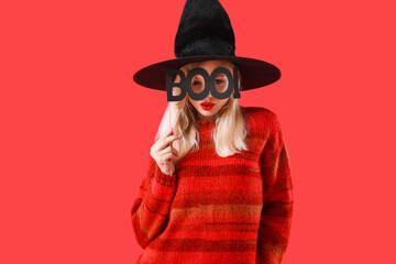 Beautiful young witch on color background. Halloween celebration