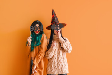 Beautiful young women with Halloween decor on color background