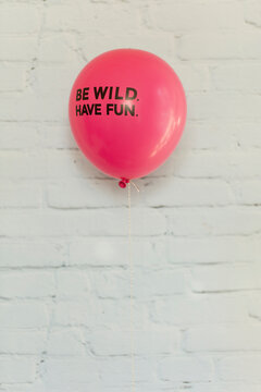 Fluo pink balloon with bold mot written on it