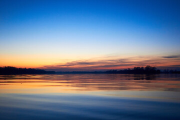 Fototapeta na wymiar Sunset over the river during the cold season