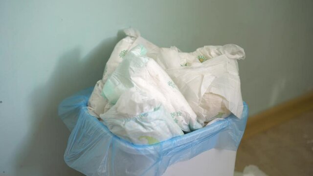 Dirty baby diapers into the trash. Disposing of used nappies