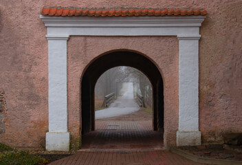old historical arch, road through the arch in the fog