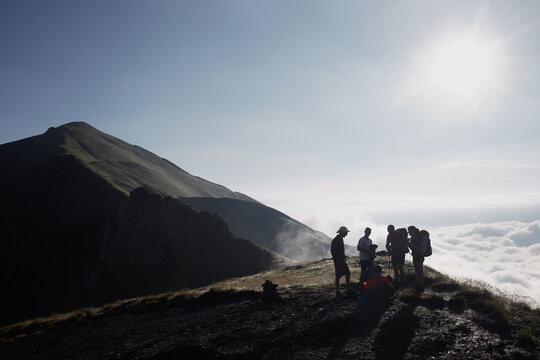 Group of hikers taking a break and enjoying the view of the scenic seacloud