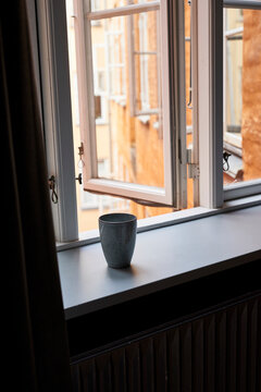 Cup on open window-sill