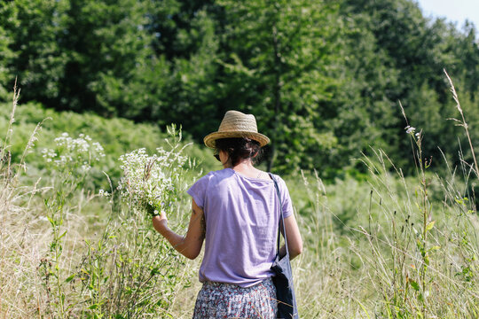 Woman from behind, holding flowers