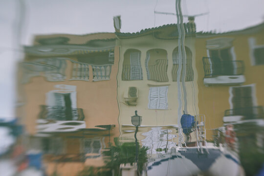 Water reflection of a scene with a house and boats