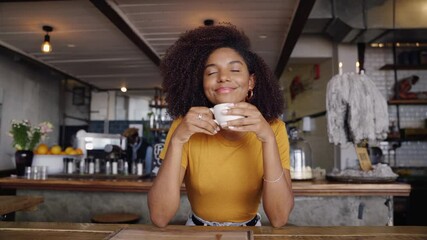 Beautiful mixed race teenage simply drinking hot coffee in stylish cafe