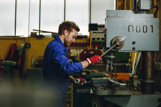 portrait of a locksmith operating a drilling machine
