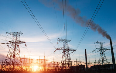 Fototapeta premium High voltage power lines at sunset. Thermal power plant. High-voltage transformer substation