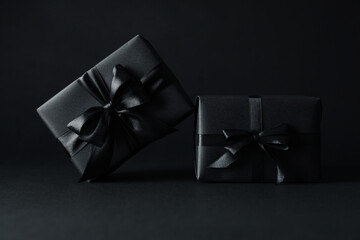 Gift boxes with black bows on black background