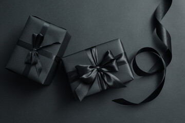 Gift boxes with black bows on black background