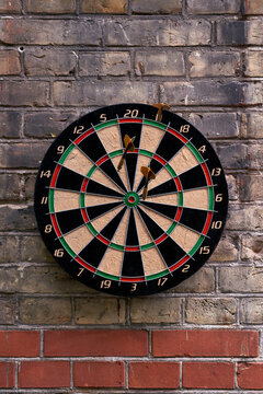 Classic darts board on brick wall