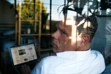 middle aged male wearing business casual clothes working on tech device indoors apartment office