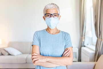 Senior woman in respiratory mask. Masked woman looks at camera. Cold, flu, virus, tonsillitis, respiratory disease, quarantine, epidemic concept.