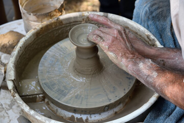 Master potter using a potter's wheel creates a vase from clay