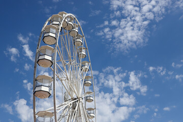 White ferris wheel against a blue sky background
