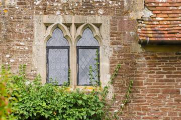 Fototapeta na wymiar Black leaded windows in a stone surround in an old medieval cottage