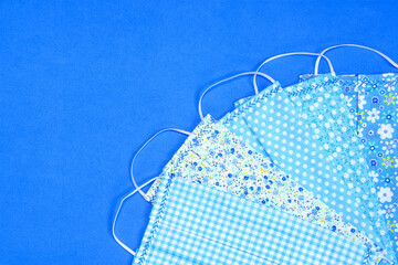 Blue homemade face masks against a plain background for protection from coronavirus