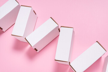 White cardboard flat postal box, case, on pink desk