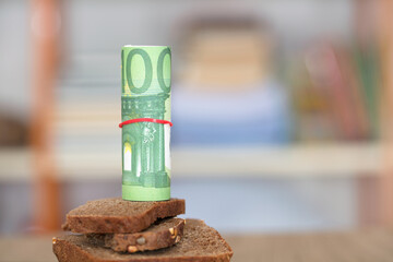 Euro banknote on black bread
