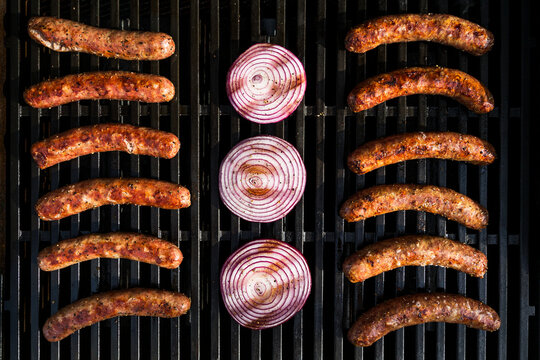 Bratwurst, Kielbasa and red onion on the grill