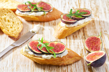 Sandwich with cream cheese, figs on a wooden table. Healthy food concept.