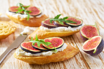 Sandwich with cream cheese, figs on a wooden table. Healthy food concept.