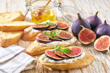 vegetarian breakfast with fig, cream cheese and honey  on a wooden table.