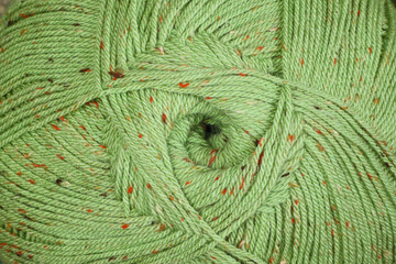 Abstract textured background of close up detail of a green ball of wool