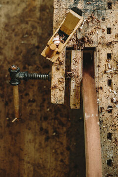old and used workbench with a bench vice, wood plane and wood chips from above