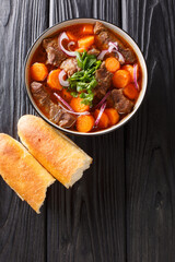 Bo kho is a delicious Vietnamese pot roasted beef stew closeup in bowl on the table. Vertical top...
